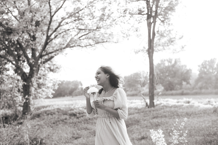 Senior girl poses in a grassy field in Oklahoma for a country photo session