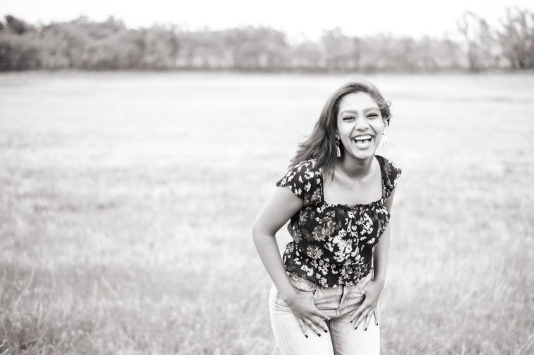 Senior girl poses in a grassy field in Oklahoma for a country photo session