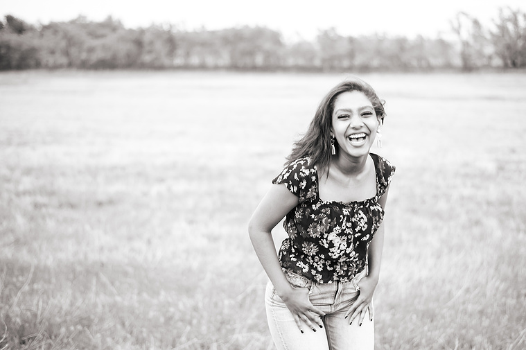 Senior girl poses in a grassy field in Oklahoma for a country photo session