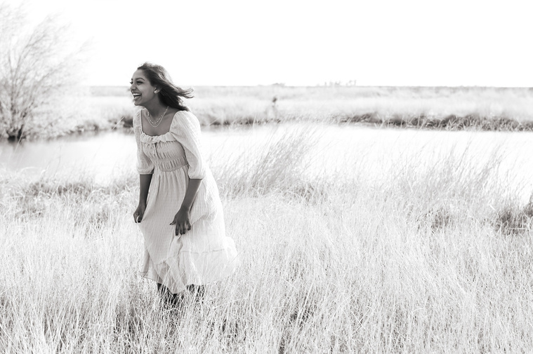 Senior girl poses in a golden field in Oklahoma for a country photo session