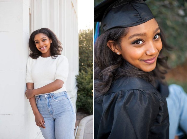 African-American teenage girl stands against a white building, sits in her cap and gown and smiles at her cap and gown senior photo shoot in Norman Oklahoma