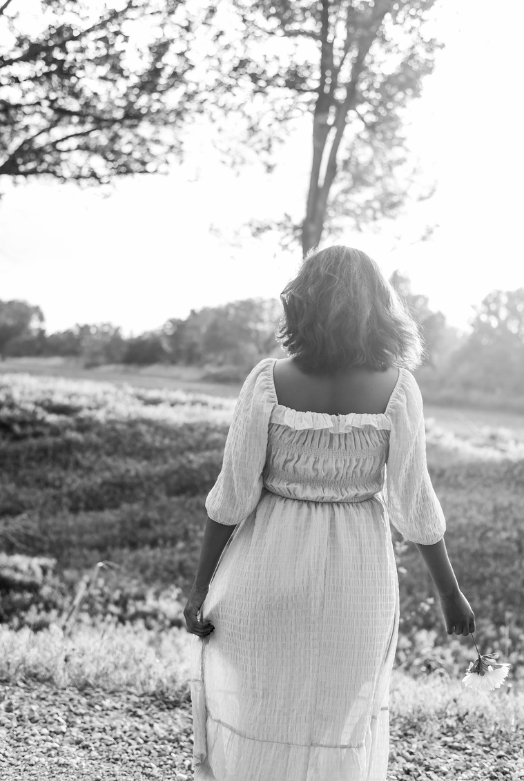 Senior girl poses in a grassy field in Oklahoma for a country photo session