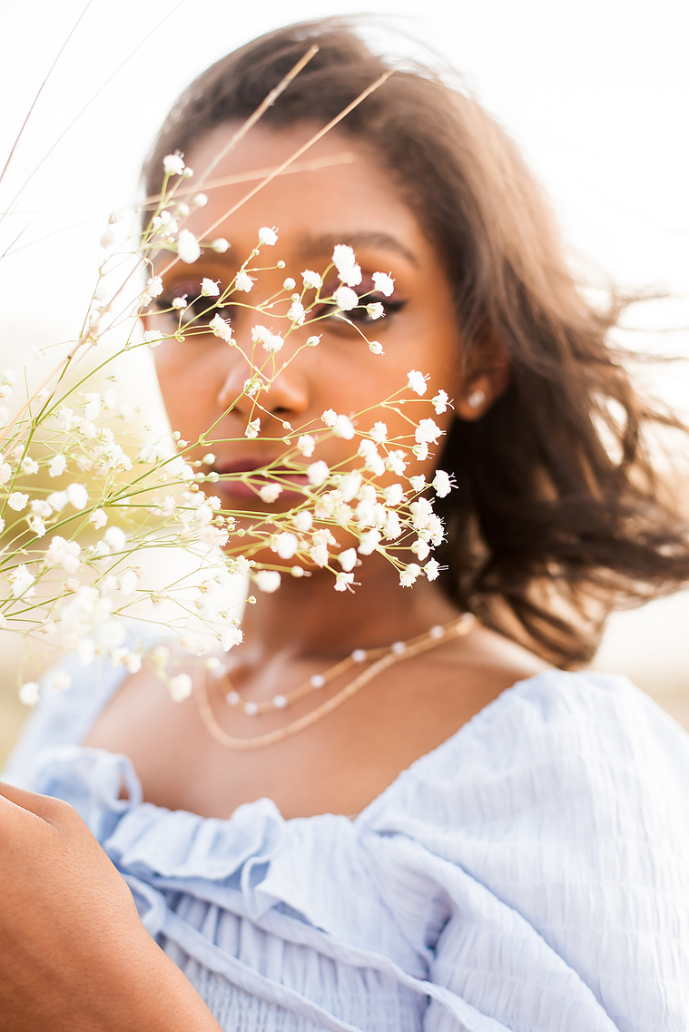 Senior girl poses with baby's breath flowers in front of her face in Oklahoma for a country photo session