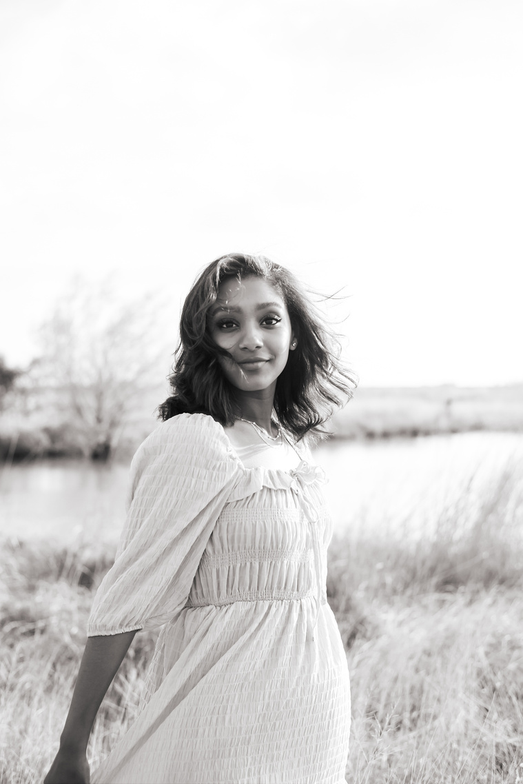 Senior girl poses in a grassy field in Oklahoma for a country photo session