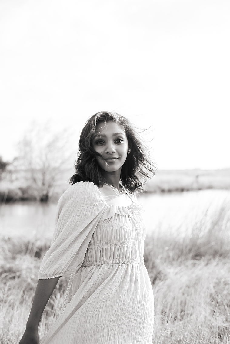 Senior girl poses in a grassy field in Oklahoma for a country photo session