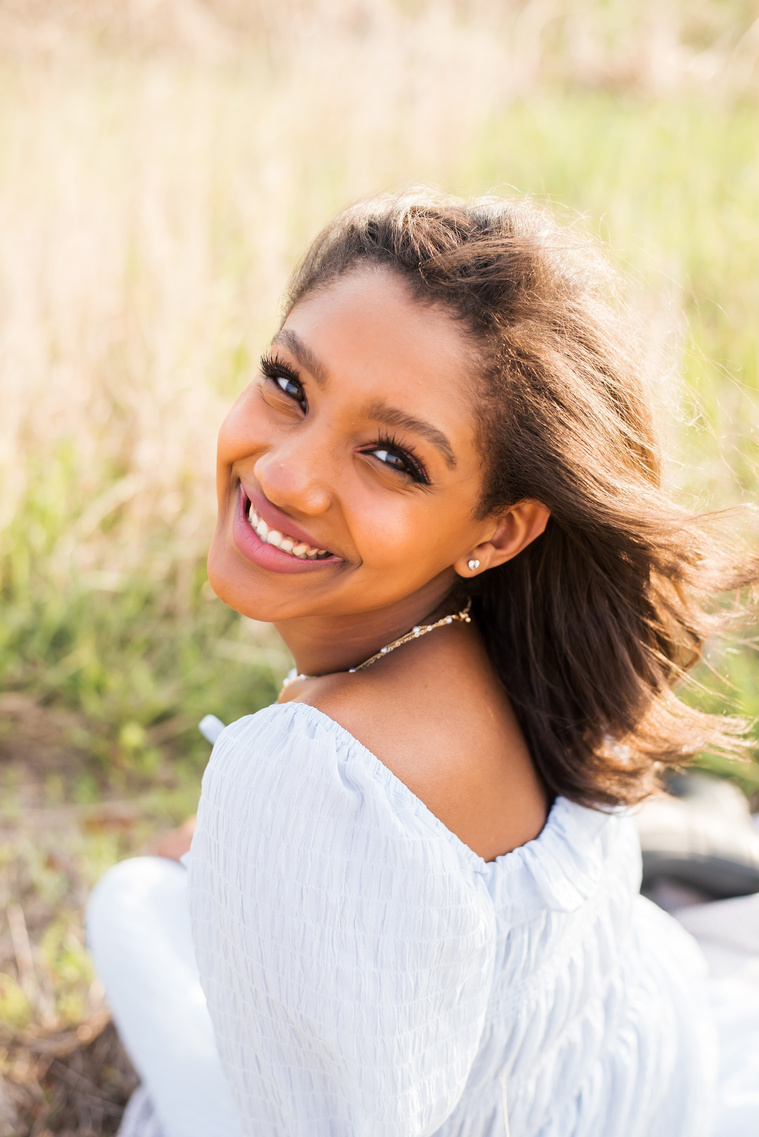Senior girl poses in a golden field in Oklahoma for a country photo session