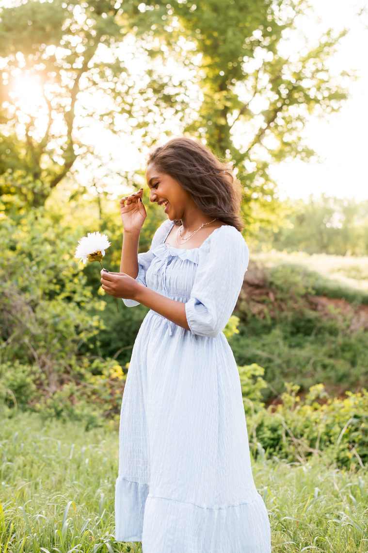 Senior girl poses in a grassy field in Oklahoma for a country photo session