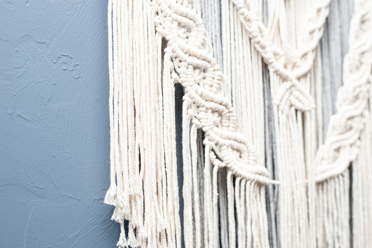 close up image of a macrame wall hanging on a blue wall at a branding session at Vibe Beauty Bar in Tuttle, Oklahoma