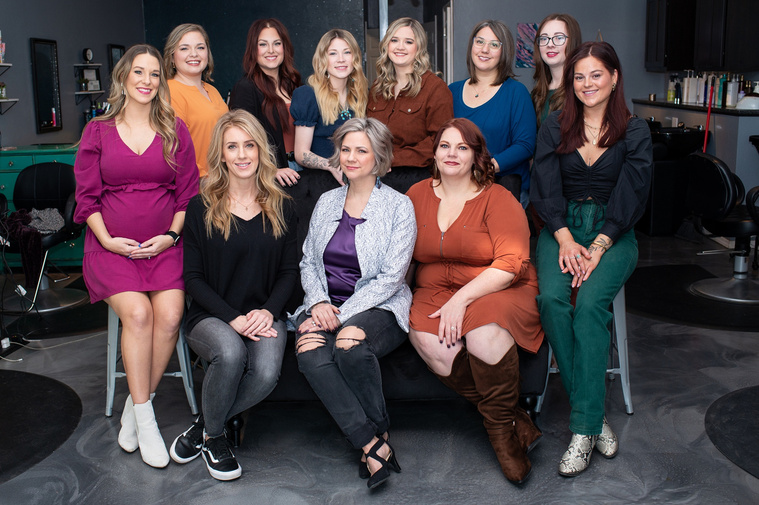 formal team photo of cosmetologists sitting and standing together smiling at a branding session at Vibe Beauty Bar in Tuttle, Oklahoma