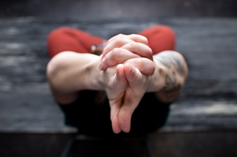 looking down from above a woman in a yoga pose on a mat where her hands are in focus at a branding session at Vibe Beauty Bar in Tuttle, Oklahoma