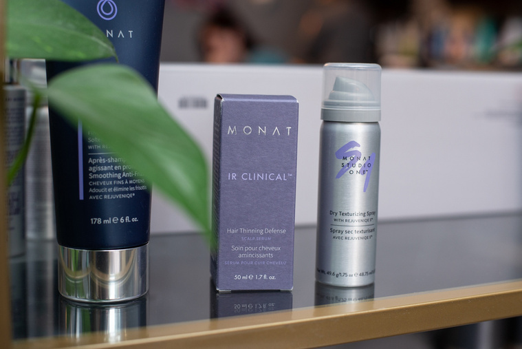 close up shot of hair products for sale on a glass shelf with brass trim at a branding session at Vibe Beauty Bar in Tuttle, Oklahoma