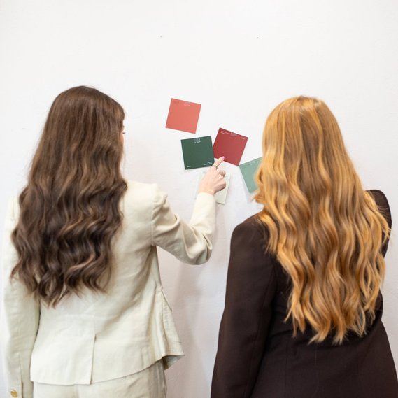 square image of two business owners facing a wall of color swatch options for a project at a graphic design team branding session in OKC