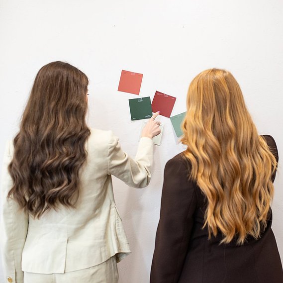 square image of two business owners facing a wall of color swatch options for a project at a graphic design team branding session in OKC