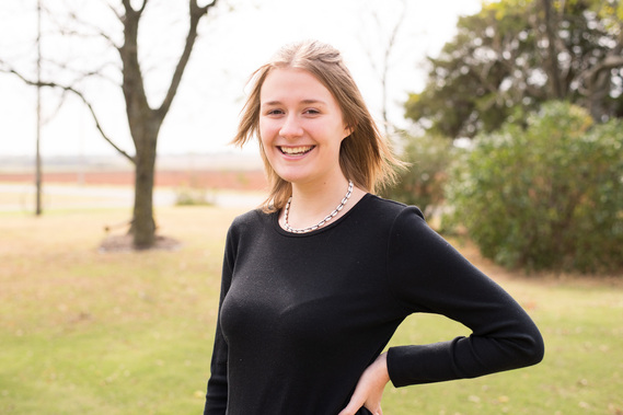 Portrait of a teenage girl in a black t-shirt in a park smiling 