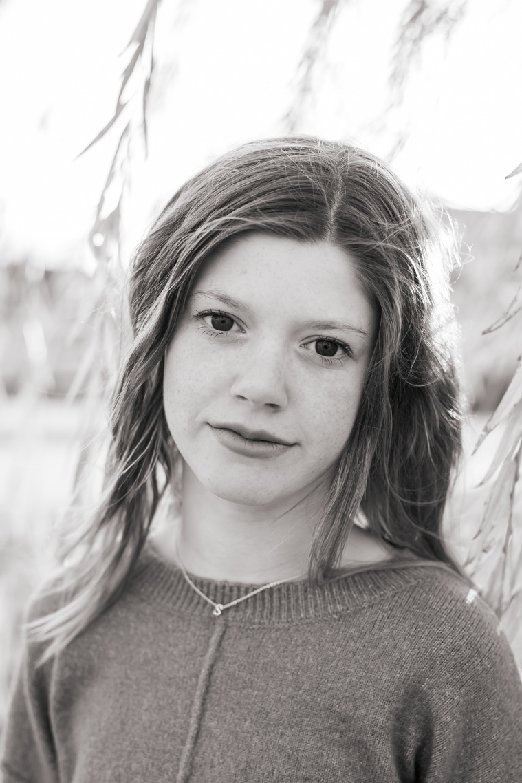 black and white photo of a teen girl smiling softly at Scissortail park in Oklahoma City