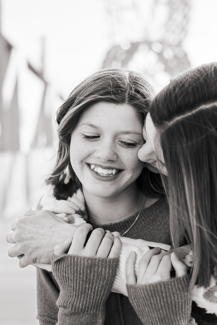 a mom and her teen daughter hug each other as mom looks at daughter, black and white, Scissortail Park in Oklahoma City