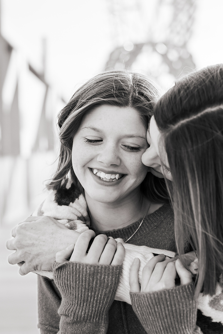 a mom and her teen daughter hug each other as mom looks at daughter, black and white, Scissortail Park in Oklahoma City