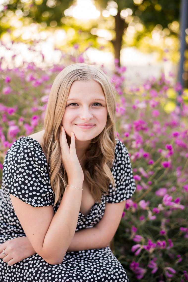 blond high school senior girl wearing a dress posing for senior pictures at Myriad Gardens in downtown Oklahoma City