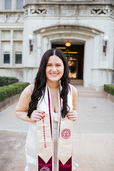 college senior girl wearing her collegiate stole smiles in front of the chemistry building on the campus of OU in Norman Oklahoma