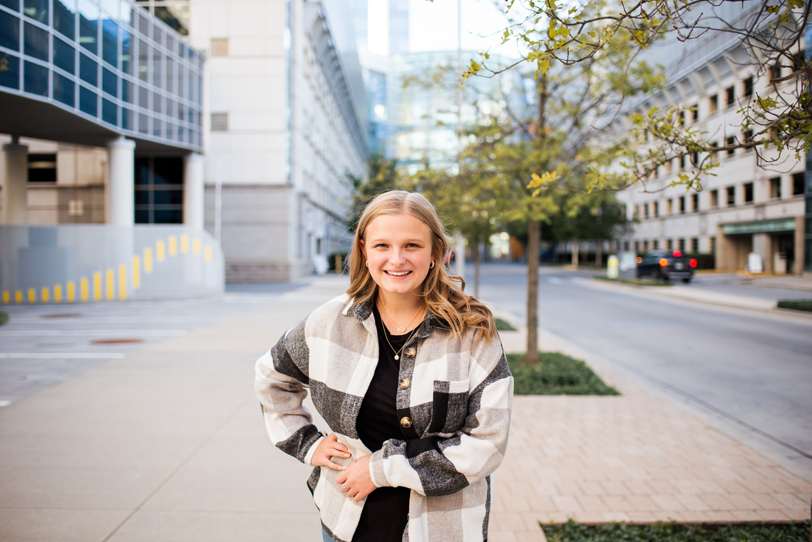 Blond high school senior girl standing in front of Devon Tower building in downtown Oklahoma City