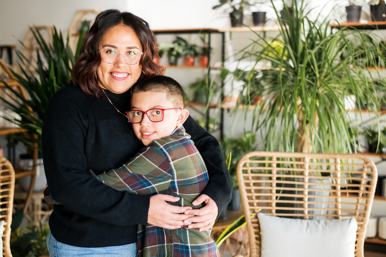 a mom and son hug each other and smile at a plant shop in Oklahoma City Oklahoma