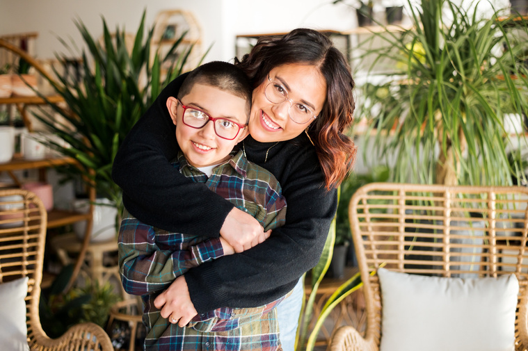 a mom and son hug each other and smile at a plant shop in Oklahoma City Oklahoma