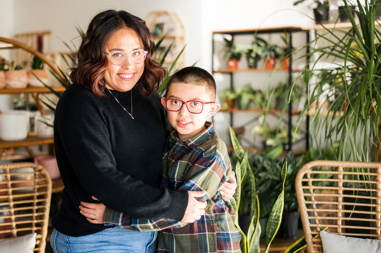 a mom and son hug each other and smile at a plant shop in Oklahoma City Oklahoma