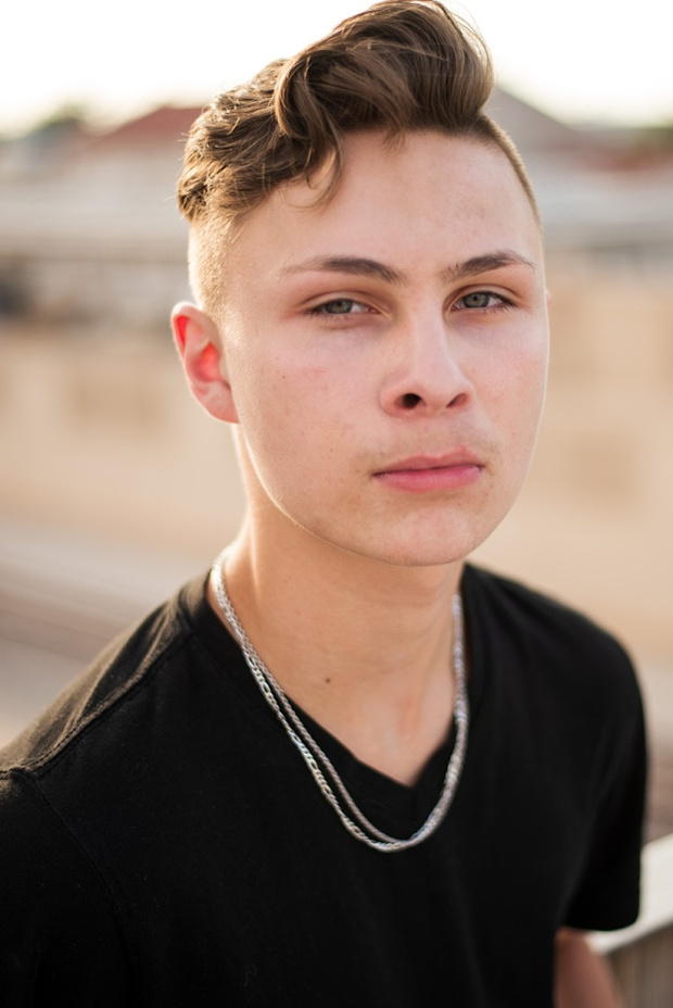 Headshots and portraits of a teen boy in downtown Oklahoma City. Scissortail Park and Parking Garage Rooftop with OKC skyline in background.