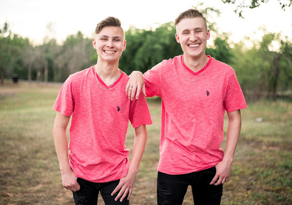 Two teen brothers dressed alike stand near each other and smile in a park in Tuttle Oklahoma