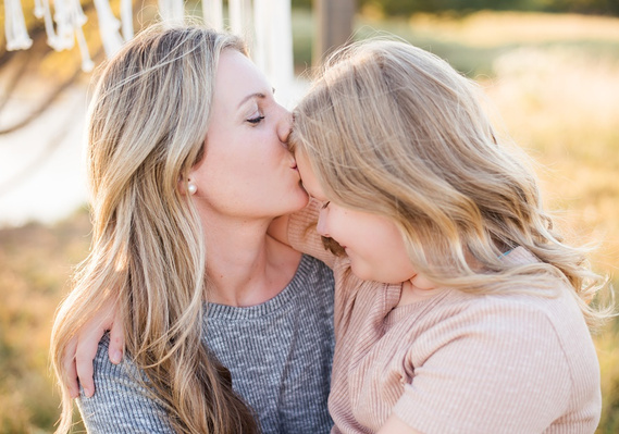 a mother kisses her daughter on the forehead at a fall boho photo session in Tuttle Oklahoma