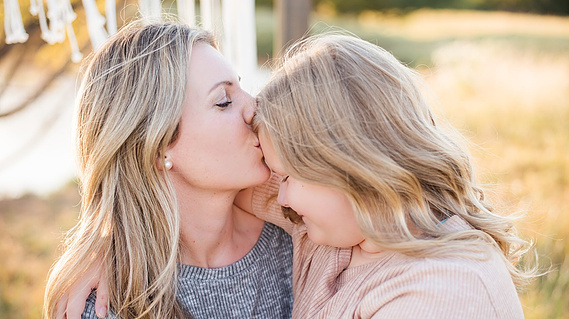 a mother kisses her daughter's forehead at a fall boho mini session in Tuttle Oklahoma
