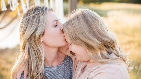 a mother kisses her daughter's forehead at a fall boho mini session in Tuttle Oklahoma
