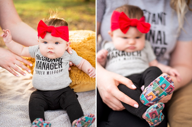 Baby girls sits up on a pouf and is also held by her mom showing her 