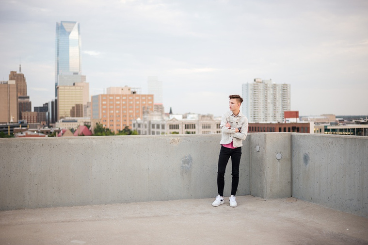 Headshots and portraits of a teen boy in downtown Oklahoma City. Scissortail Park and Parking Garage Rooftop with OKC skyline in background.