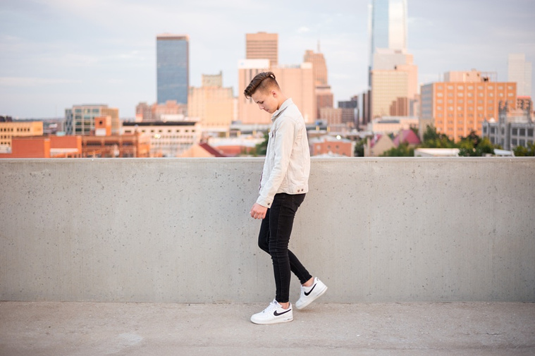 Headshots and portraits of a teen boy in downtown Oklahoma City. Scissortail Park and Parking Garage Rooftop with OKC skyline in background.