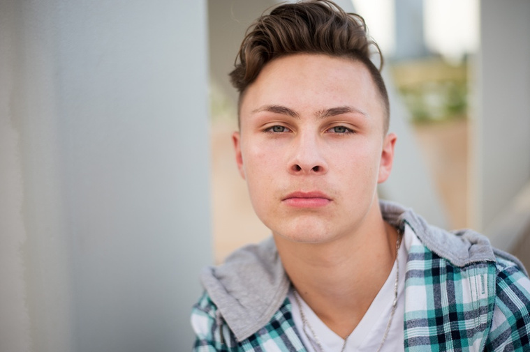 Headshots and portraits of a teen boy in downtown Oklahoma City. Scissortail Park and Parking Garage Rooftop with OKC skyline in background.