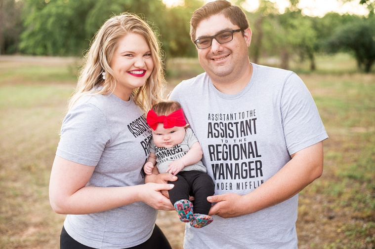 Mom and Dad hold their baby girl in the park wearing 