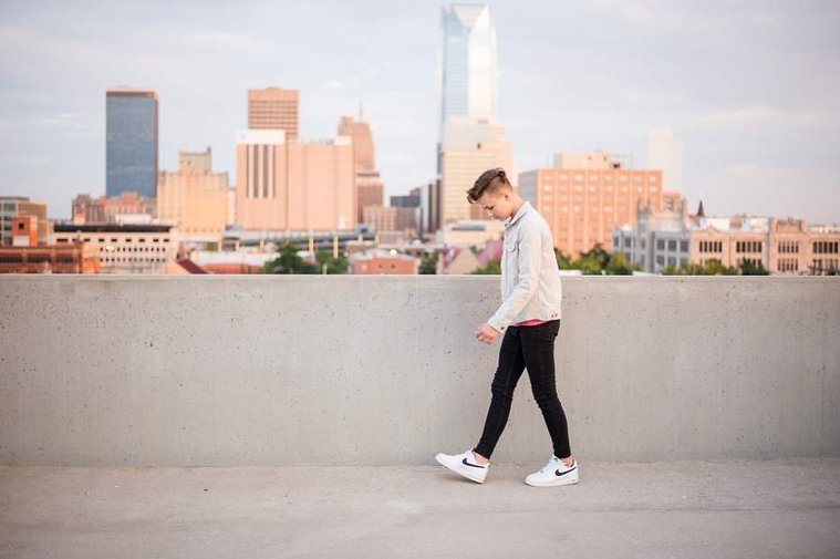 Headshots and portraits of a teen boy in downtown Oklahoma City. Scissortail Park and Parking Garage Rooftop with OKC skyline in background.