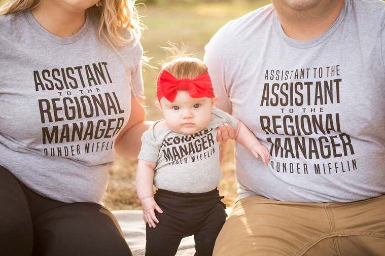 Mom and Dad hold their baby girl in the park wearing 