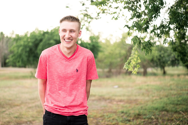 Teen boy posing and laughing casually in a park in Tuttle Oklahoma