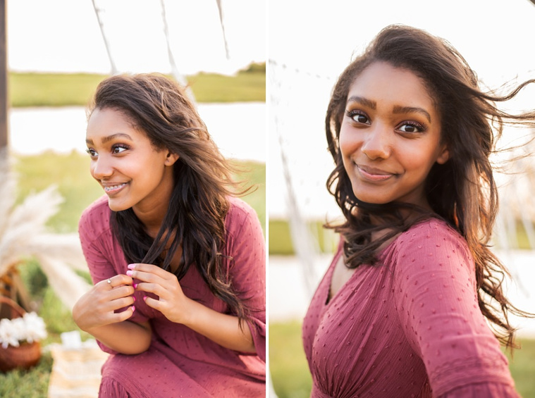 A senior girl dressed in boho style poses in front of boho decorations and a field and pond in the country in Oklahoma