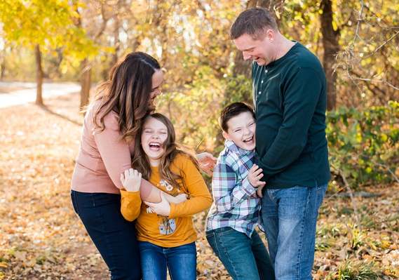 a mom and dad tickle their son and daughter at a playful family photo session in Moore, Oklahoma