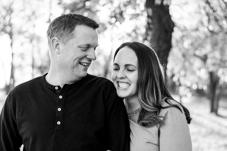 black and white image of a husband and wife. She is smiling off camera and he is looking at her and smiling at a family photo session in Moore, Oklahoma