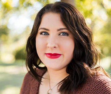 close-up portrait of a senior high school girl in a brown sweater smiling softly at Will Rogers Park in Oklahoma City, Oklahoma