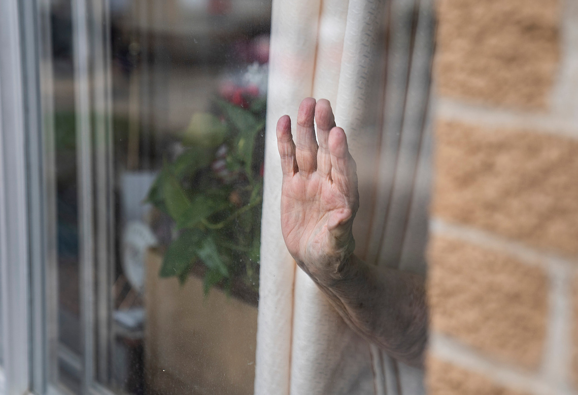 A Spring Valley Resident waves through their window as Carr’s Clubhouse daycare visits with residents through the windows during their lockdown to help stop the spread of COVID-19 on Thursday, April, 2, 2020, at the center in Spring Valley, Minnesota. 
