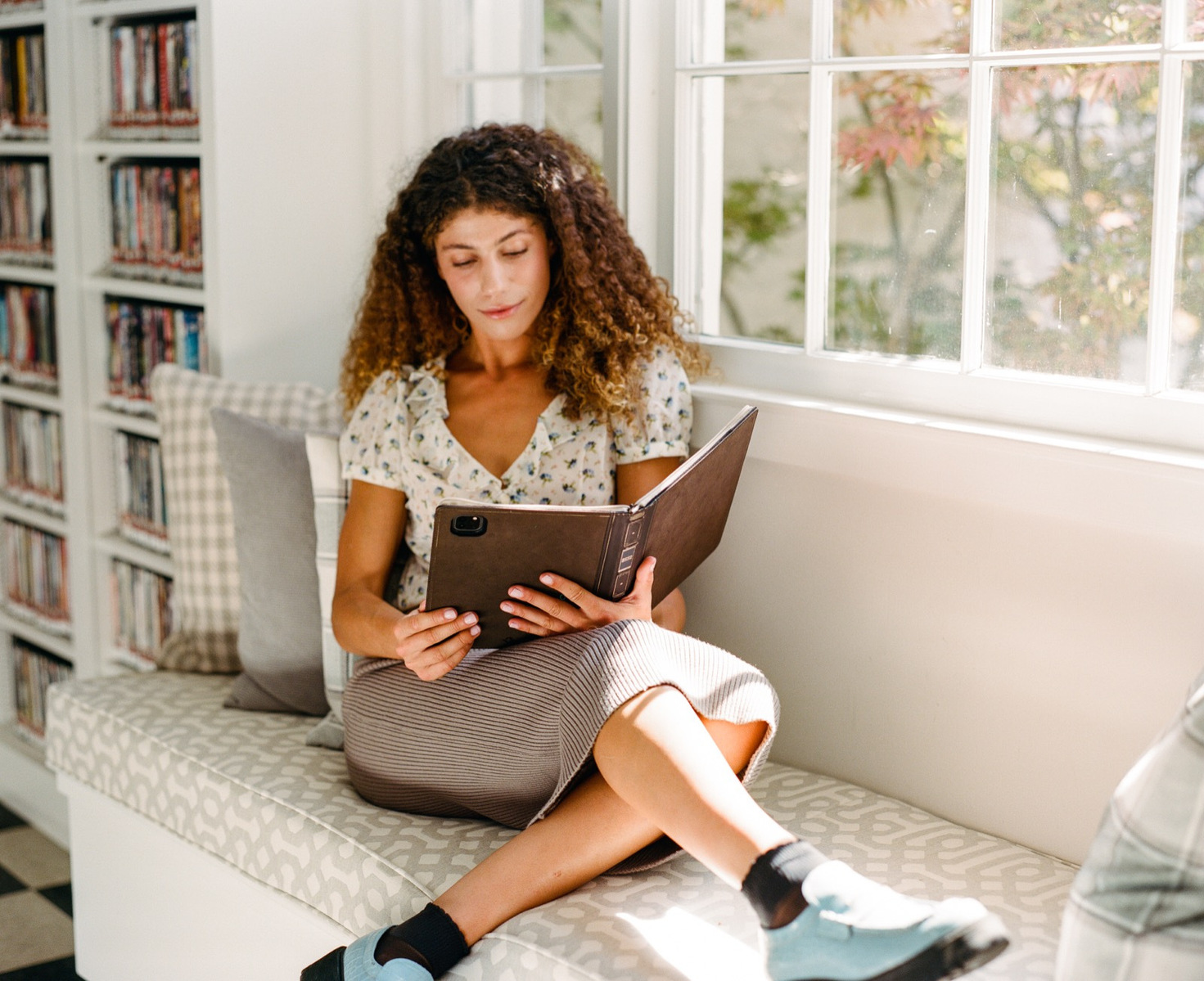 A young professional reading inside a historic library with BookBook products in hand