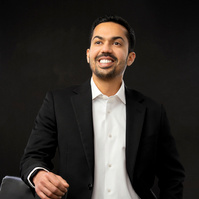 Men in suit smiling at camera. 