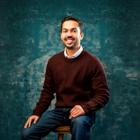 man casual in sweater smiling. 