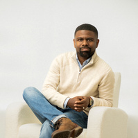 Man sitting in a chair. White background, and casual clothes by Image Concepts. 
