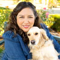 Woman in jean jacket with yellow dog smiling at camera. Clothing styling by Image Concepts.